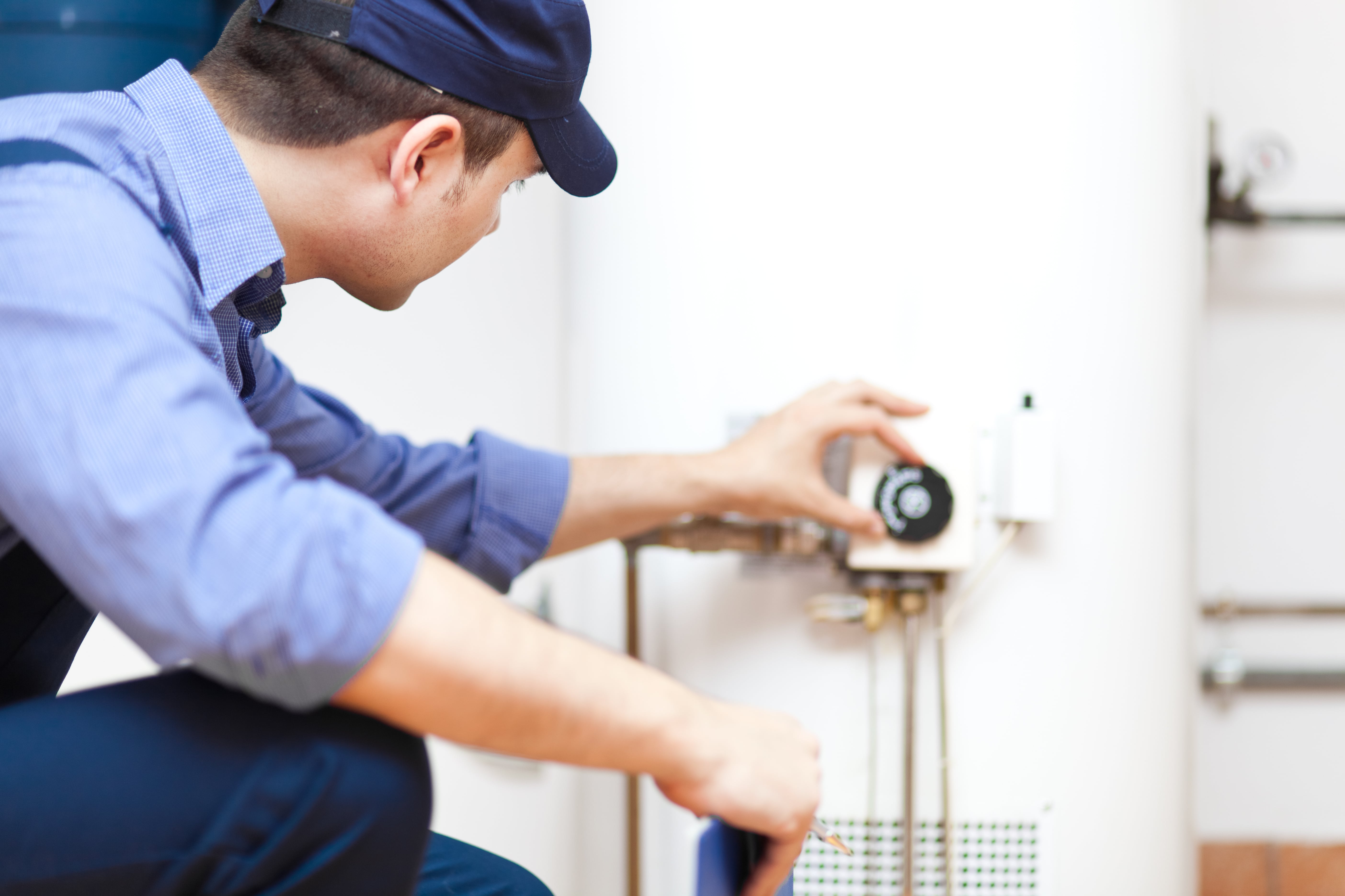 Technician performing maintenance on an air conditioning system.
