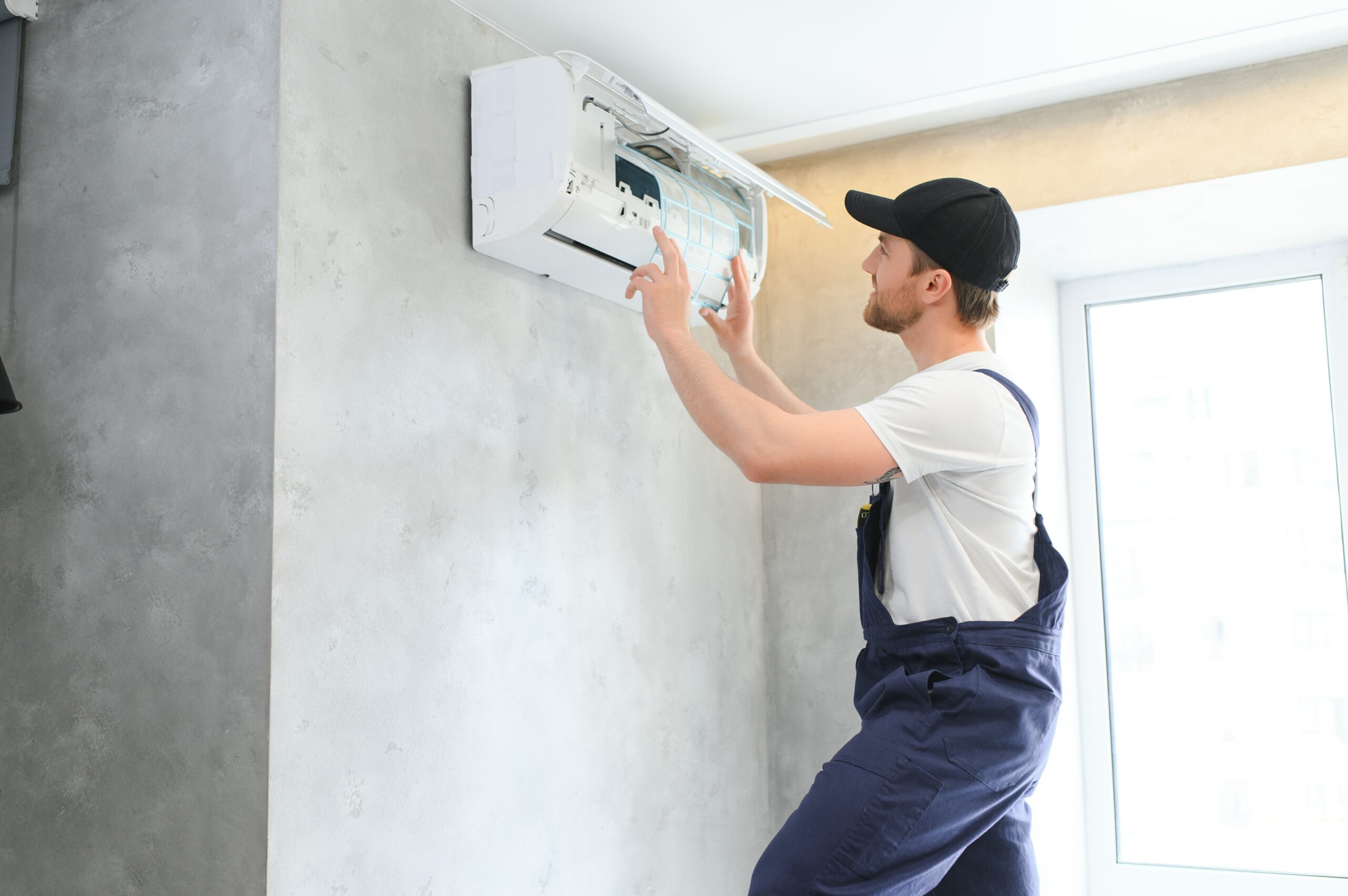 Male Technician Repairing Air Conditioner.