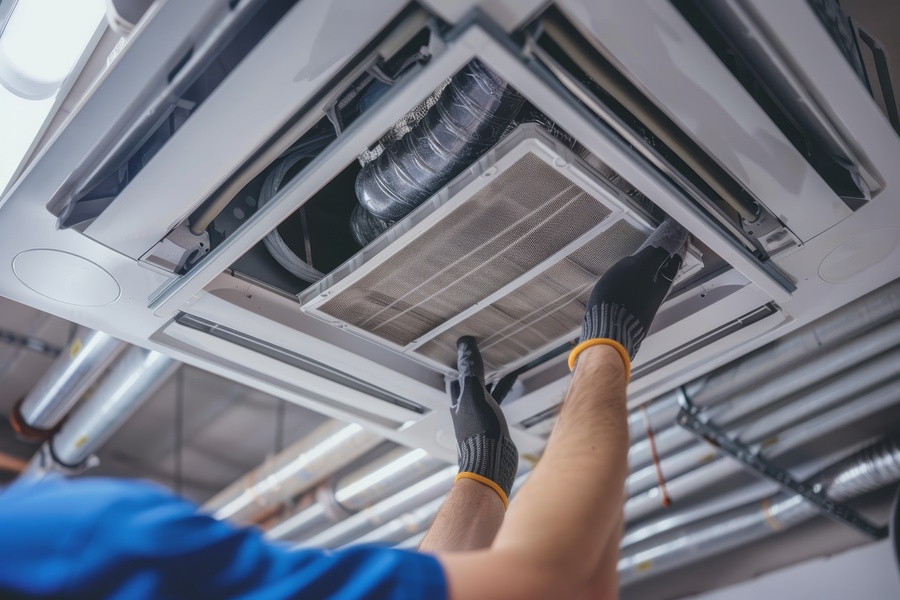 Hvac technician replacing dirty air filter in central ventilation system for improved air quality